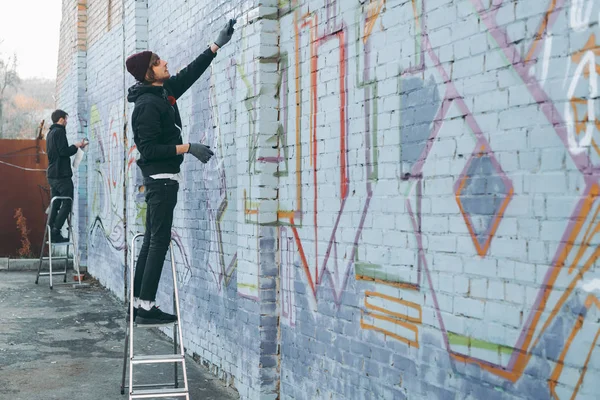 Straßenkünstler Stehen Auf Leitern Und Malen Bunte Graffiti Auf Gebäude — Stockfoto