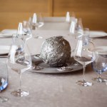 Close up view of arrangement of cutlery, decorations and empty wineglasses on table in restaurant