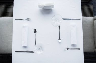 restoranda beyaz masa örtüsü ile tabloda görücü usulü çatal ve kadehlerin Üstten Görünüm