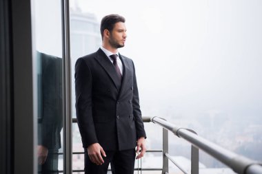 takım elbise ayakta balkon, genç dalgın adam portresi
