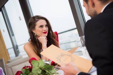 smiling woman looking at boyfriend during st valentine day date in restaurant clipart