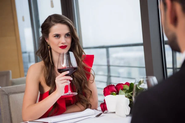 Mulher Com Copo Vinho Tinto Olhando Para Namorado Durante Data — Fotografia de Stock