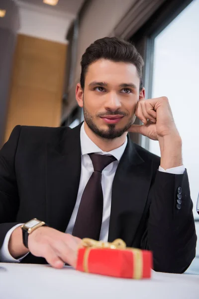 Portrait Young Man Sitting Table Wrapped Present Cafe — Stock Photo, Image