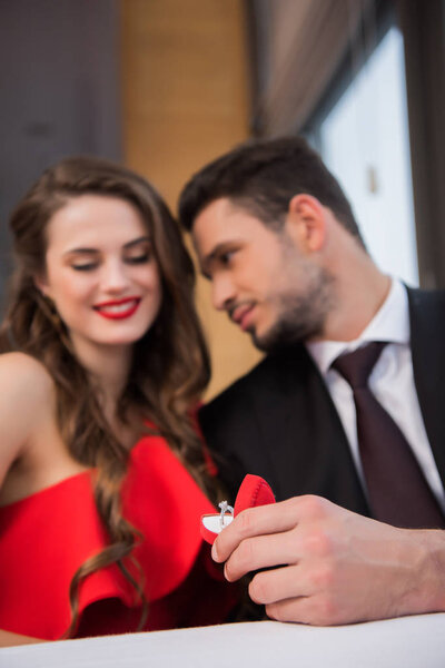 selective focus of man proposing to girlfriend in restaurant on st valentine day