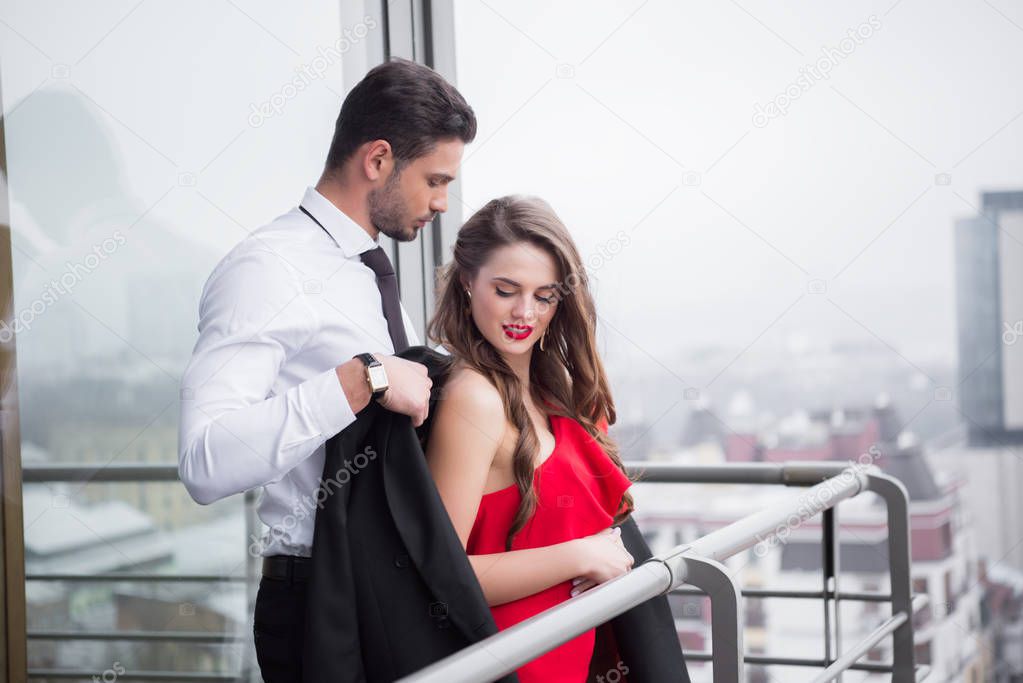 young couple in love standing on balcony together