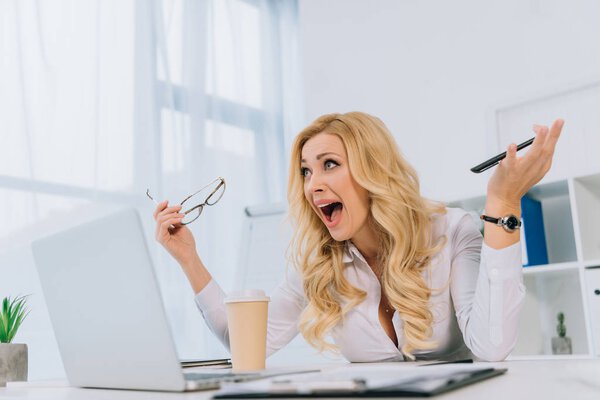 деловая женщина кричит во время работы с ноутбуком
