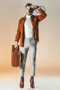 şık atlama adam elinde fotoğraf makinesi üzerinde çekim çanta