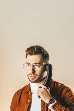 Telefonla konuşurken uzak bakan dalgın şık adam portresi üzerinde bej izole