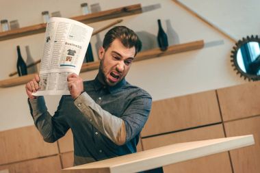 kafede masada gazete atma kızgın işadamı portresi