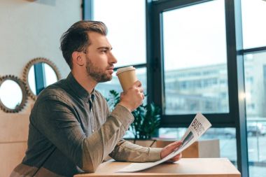 dalgın işadamı gazete kafede kahve içme ile yan görünüm