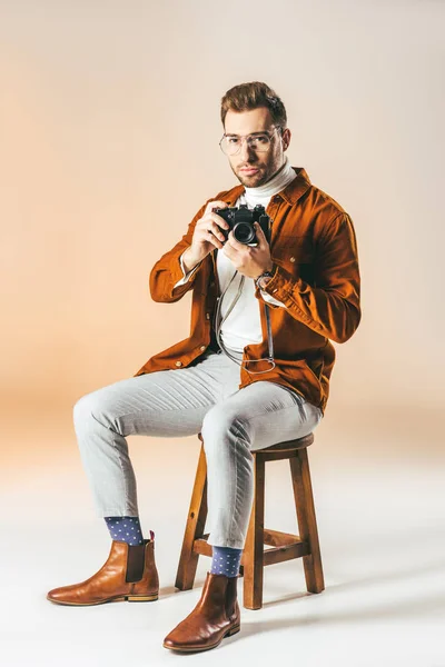 Homem Bonito Com Câmera Fotos Mãos Sentadas Cadeira Madeira — Fotografia de Stock Grátis