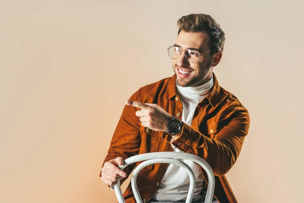 Portrait Cheerful Fashionable Man Pointing Away Isolated Beige — Free Stock Photo