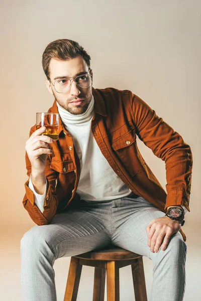 Portrait Pensive Fashionable Man Glass Whiskey Looking Away Isolated Beige — Free Stock Photo