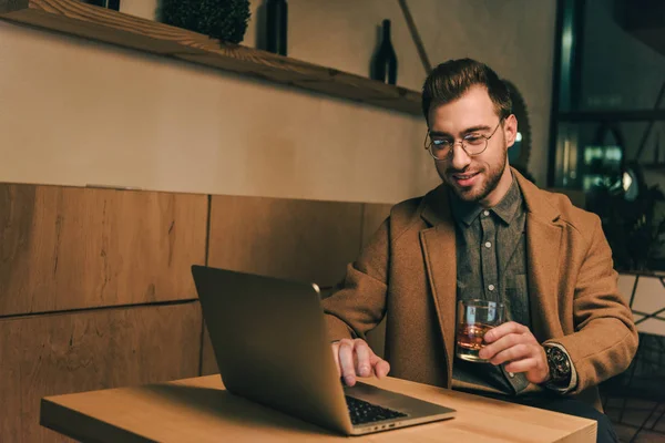 Retrato Homem Sorridente Com Copo Uísque Usando Laptop Mesa Café — Fotografia de Stock