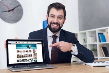 İşyeri ofis dizüstü gösteren genç işadamı portresi