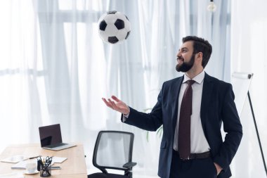 office işyerinde futbol topuyla oynayan gülümseyen işadamı portresi