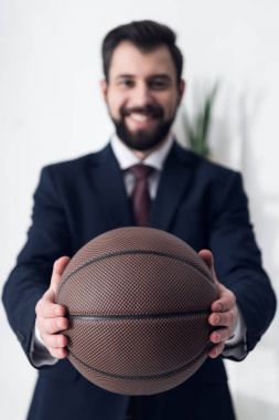 işadamı gösteren basketbol topu elinde Office gülümseyen seçici odak