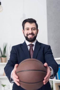 işadamı gösteren basketbol topu elinde Office gülümseyen seçici odak