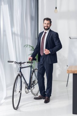 takım elbise ayakta Bisiklet Office yakınındaki gülümseyen iş adamı