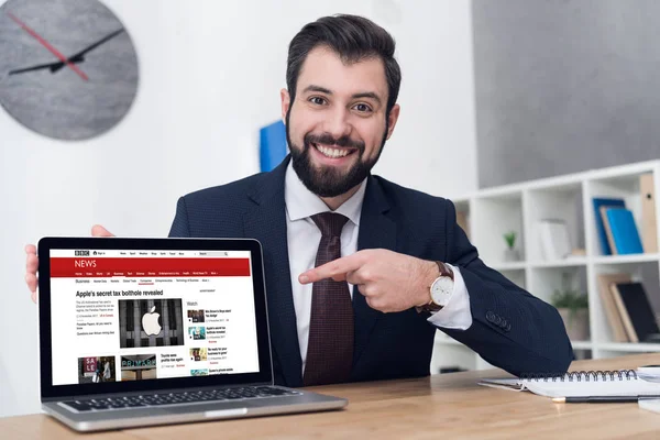 Πορτρέτο Του Χαμογελώντας Επιχειρηματίας Δείχνει Φορητό Υπολογιστή Στο Χώρο Εργασίας — Φωτογραφία Αρχείου