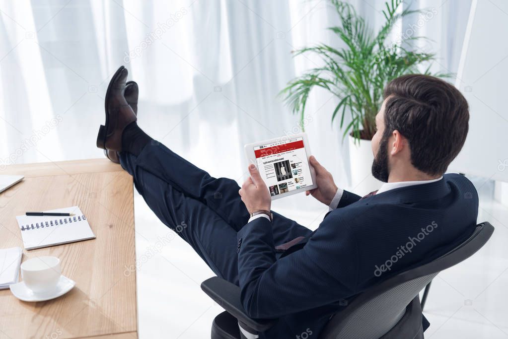 Side view of businessman using tablet at workplace in office