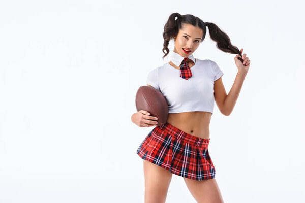 привлекательная молодая школьница с американским футбольным мячом, изолированным на белом
