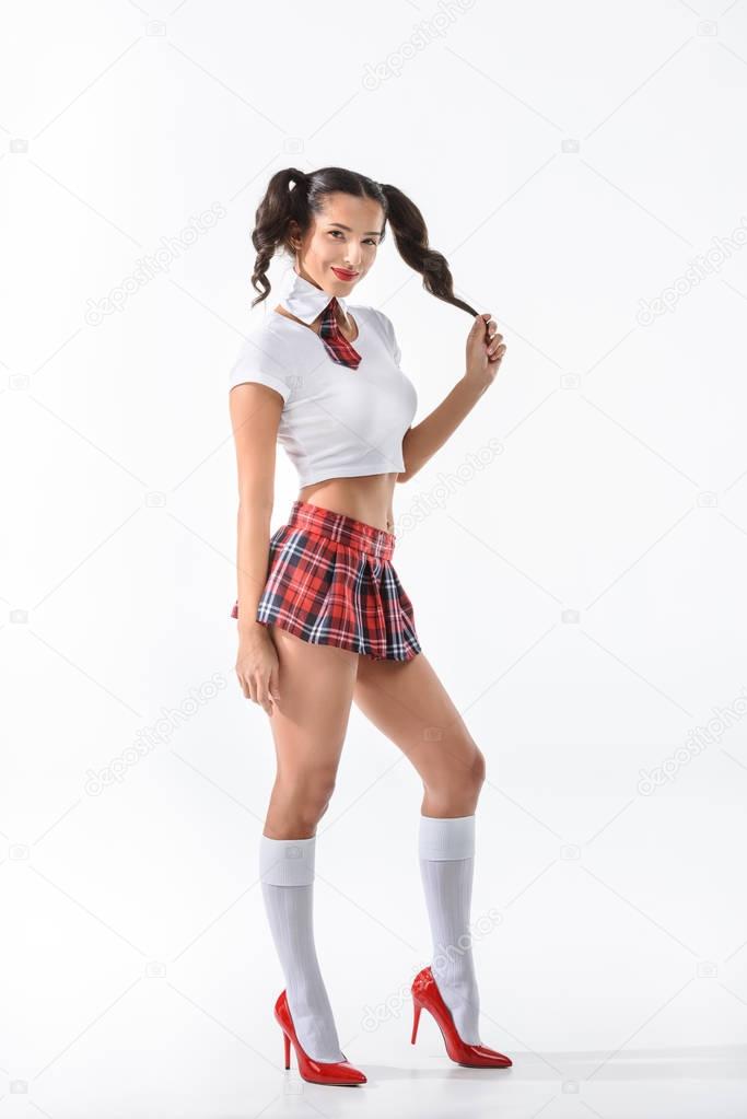 young sexy schoolgirl in short red skirt with ponytails isolated on white