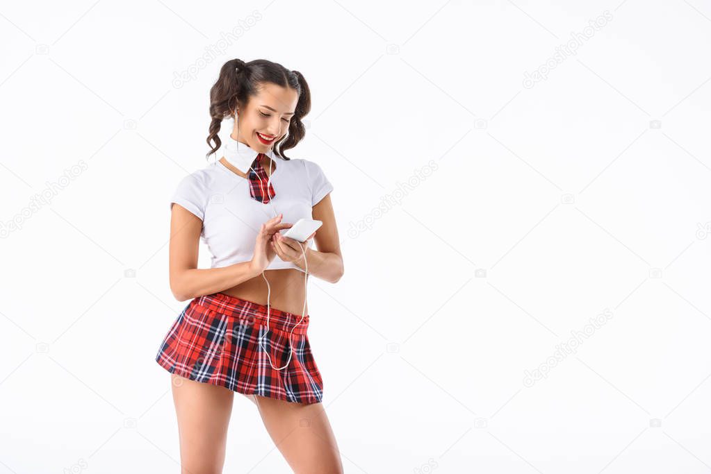 young sexy schoolgirl listening music and using smartphone isolated on white