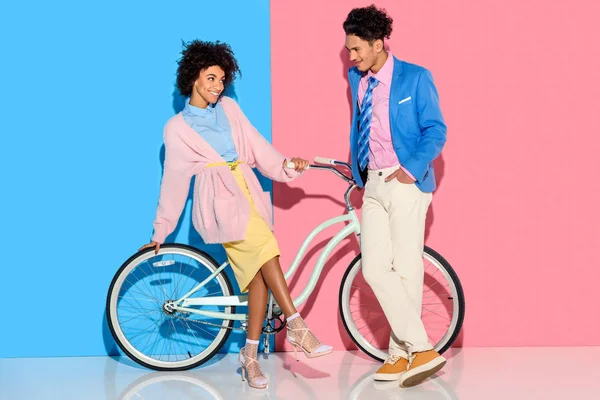 Atractiva Pareja Divirtiéndose Con Bicicleta Sobre Fondo Rosa Azul — Foto de Stock