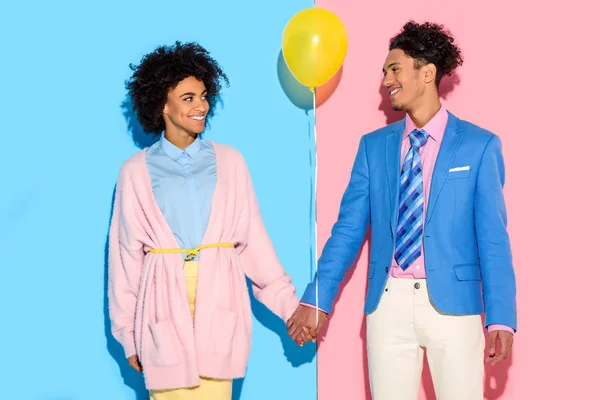 Lachende Paar Bedrijf Handen Met Luchtballon Roze Blauwe Achtergrond — Stockfoto