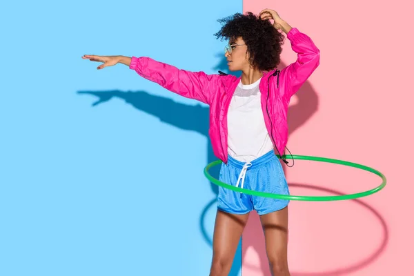 在粉红色和蓝色背景的 Exersizing 与箍的运动妇女姿势 — 图库照片