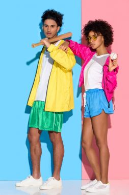 Kamera pembe ve mavi arka plan üzerinde arıyorum elinde beysbol ekipman ile çekici genç Çift  