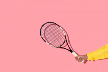 Tenis raketi, pembe arka plan tutan erkek el görünümünü yakın çekim 