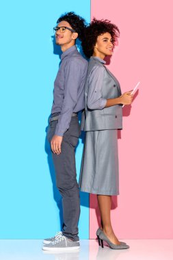 Genç Afrika amercian işadamı işkadını elinde pembe ve mavi zemin üzerine tablet ile hazır 