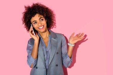 Pembe arka plan telefonla konuşurken genç Afrika amercian işkadını 