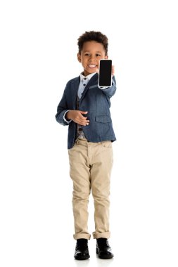 Afro-Amerikan çocuk üzerinde beyaz izole smartphone gösterilen gülümseyen