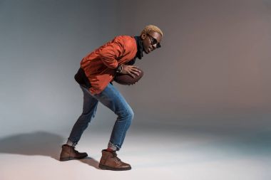 Şık genç Afro-Amerikan adam çalıştırmak için hazırlanma ragbi topu tutan 