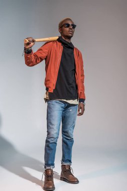 Stylish young african american man holding baseball bat  clipart