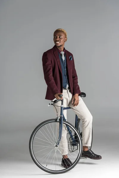 Hombre Africano Sonriente Sentado Bicicleta Mirando Hacia Otro Lado Sobre — Foto de Stock