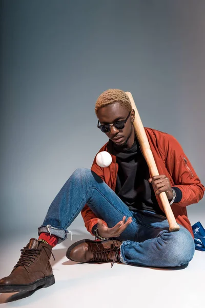 Young African American Man Sitting Holding Baseball Bat Ball Grey — Free Stock Photo