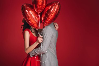 izole kırmızı balon demeti ile karşı karşıya kapsayan Çift