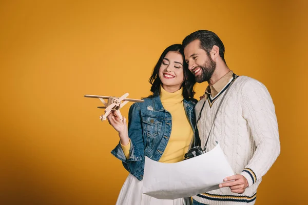 Smiling Couple Looking Wooden Plane Isolated Yellow — Stock Photo, Image