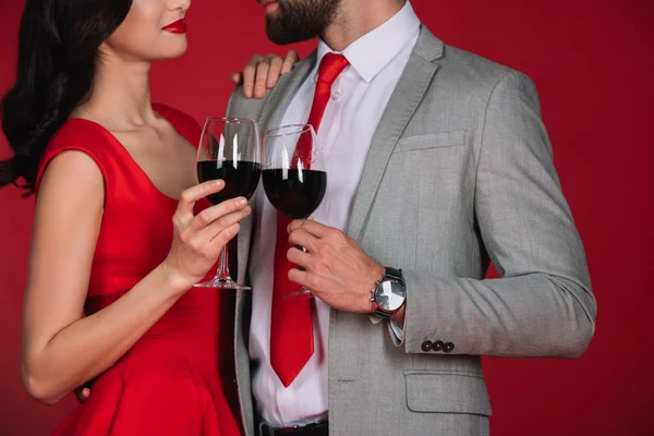 Imagen Recortada Pareja Tintineando Con Copas Vino Mirándose Aislados Rojo — Foto de Stock