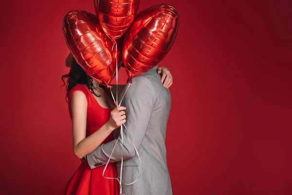 Casal Cobrindo Rostos Com Feixe Balões Isolados Vermelho — Fotografia de Stock