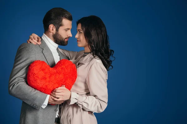 Couple Holding Heart Shaped Pillow Looking Each Other Isolated Blue — Stock Photo, Image