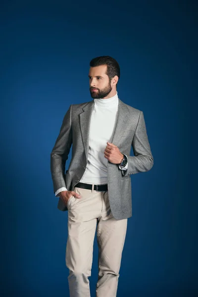 Stilig Man Står Kostym Och Tittar Bort Isolerade Blå — Stockfoto