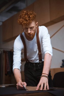 odaklı genç erkek moda tasarımcısı'nda atölye desende dikiş ile çalışma gözlük 