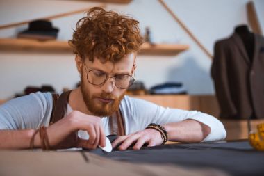 konsantre genç moda tasarımcı atölyesinde kumaş ile çalışma sakallı 