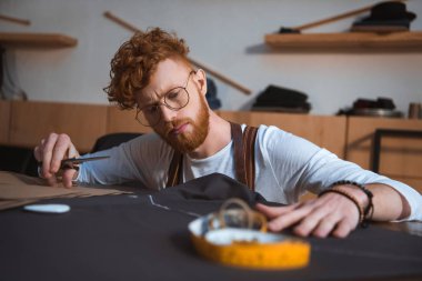 Genç sakallı moda tasarımcı atölyesinde kumaş ile çalışma odaklı 