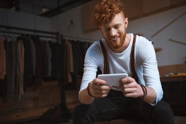 Smiling Young Male Fashion Designer Using Smartphone Workplace — Free Stock Photo